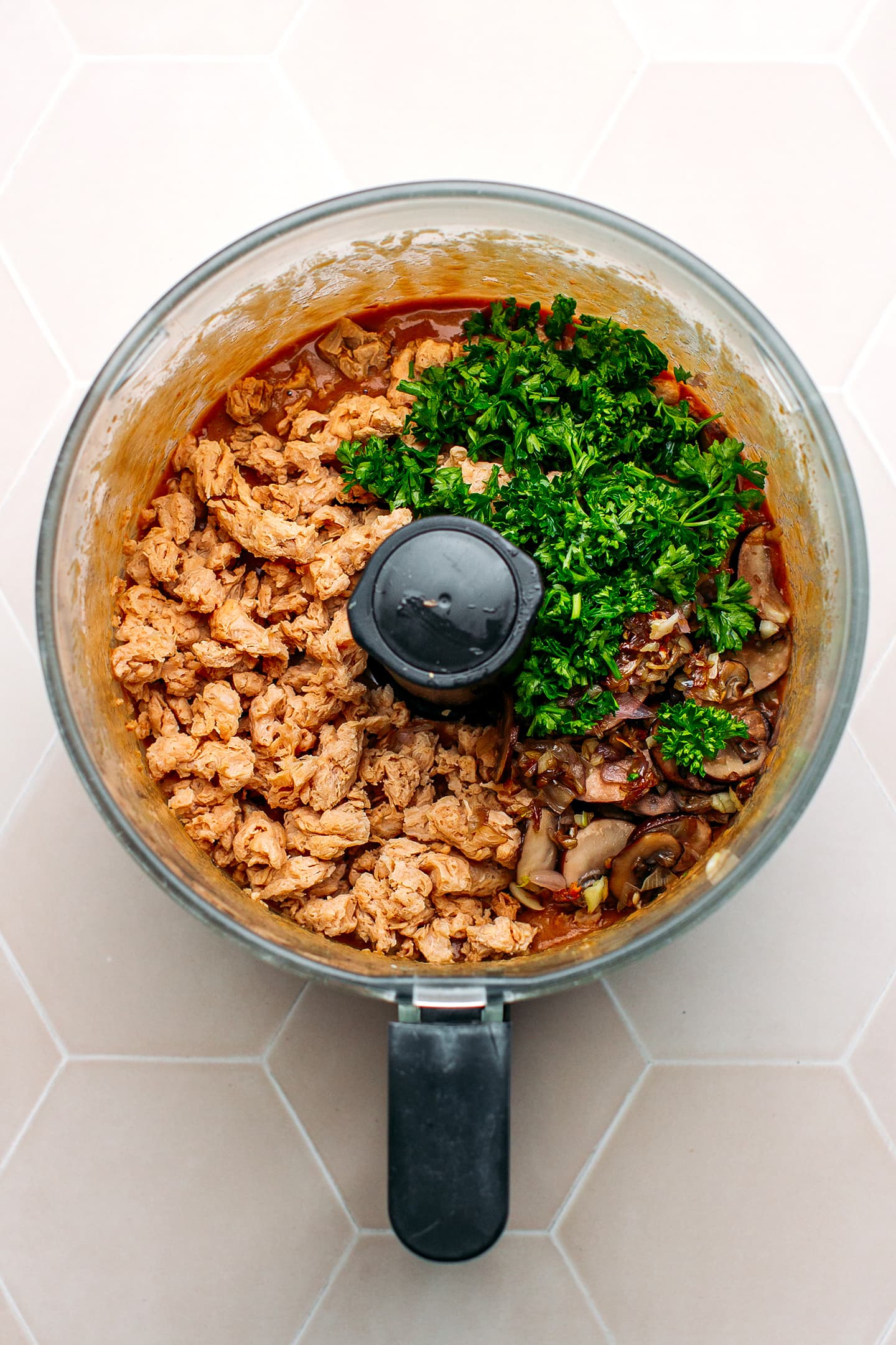 Soy curls, parsley, and mushrooms in a food processor.