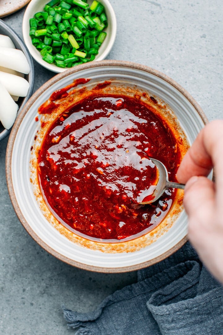 Whisking tteokbokki sauce in a small bowl.