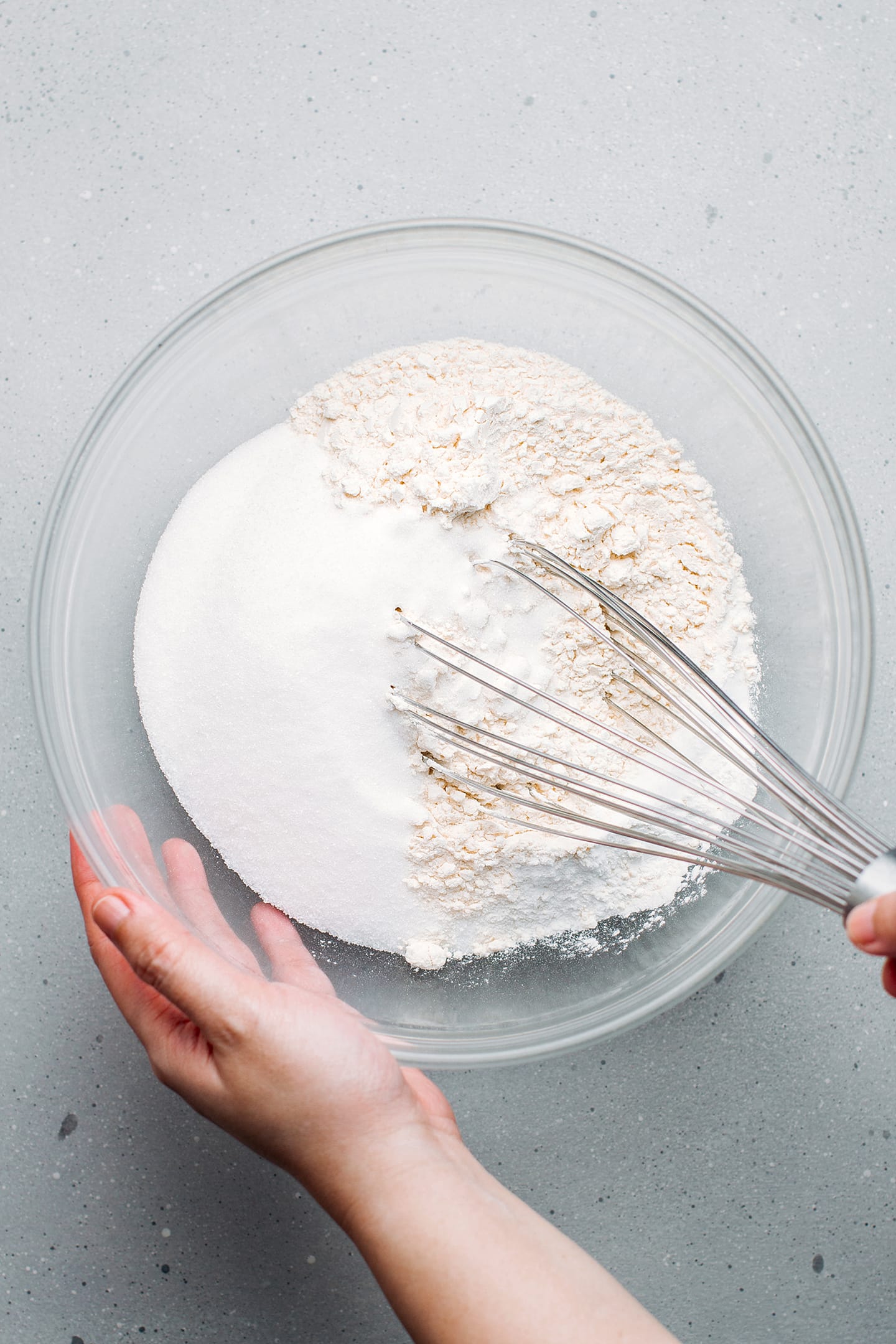 Whisking flour, sugar, and baking powder in a mixing bowl.