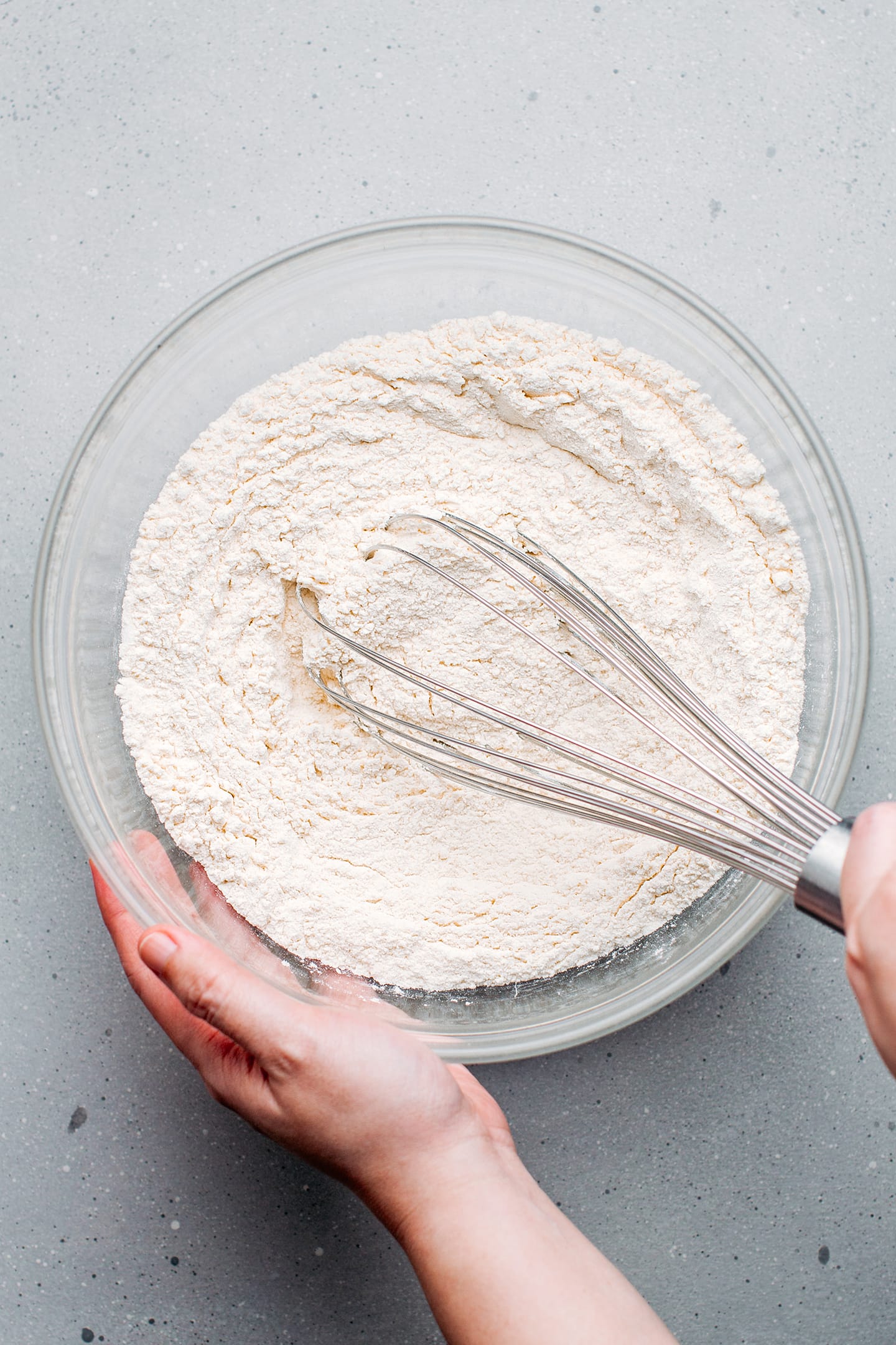 Whisking flour and sugar in a mixing bowl.