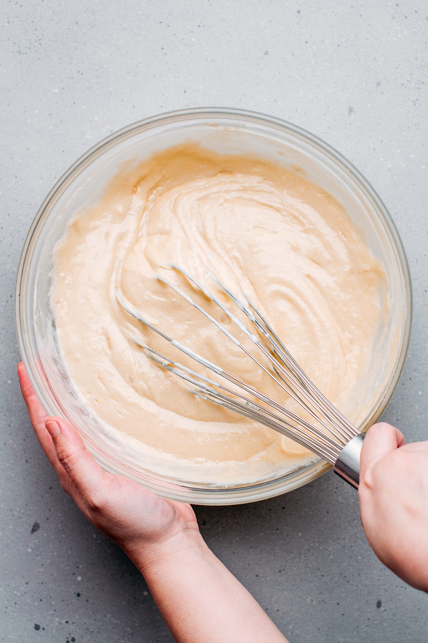 Whisking a muffin batter in a mixing bowl.
