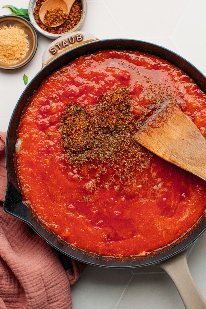 Tomato sauce and Italian herbs in a skillet.