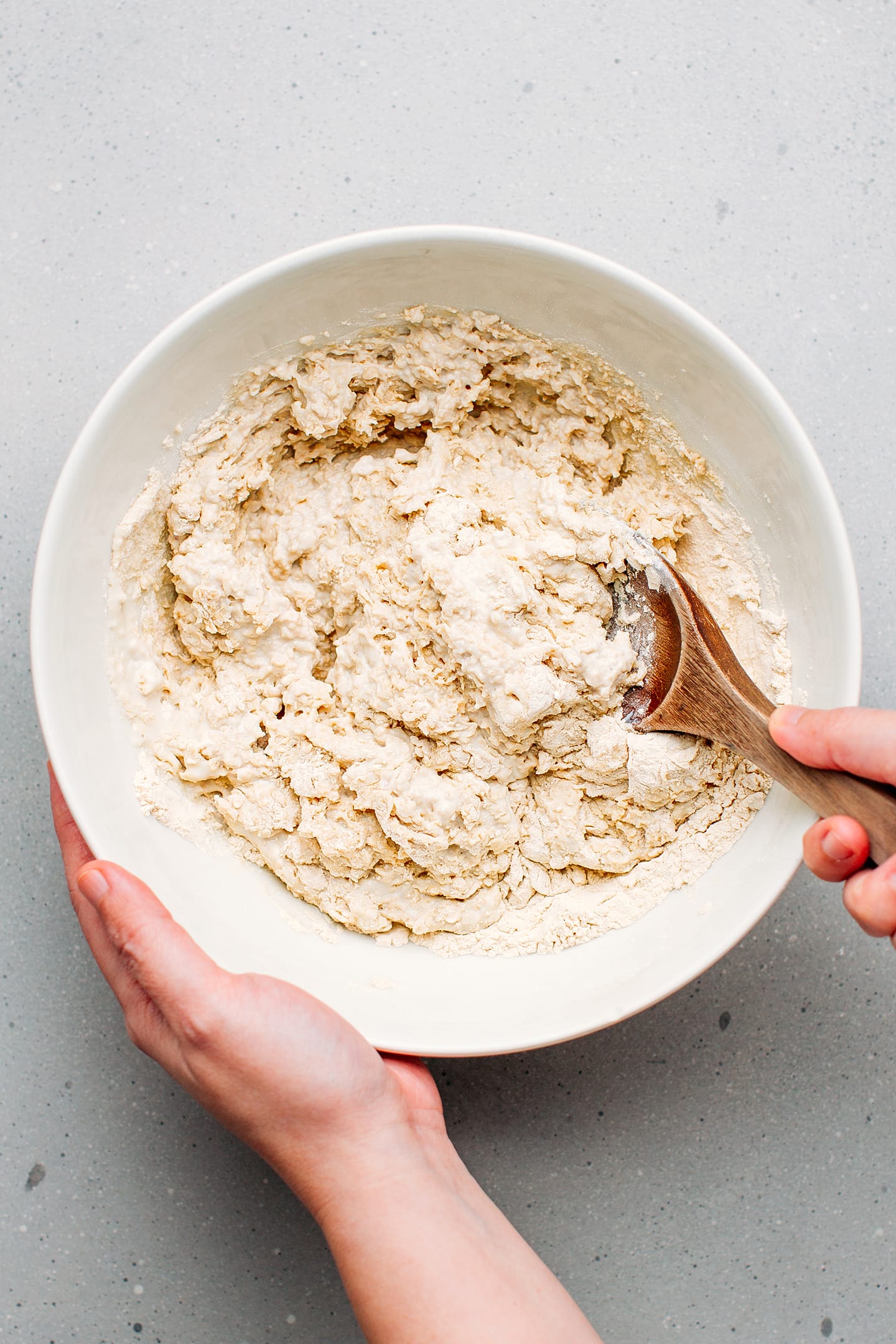 Stirring blended tofu with vital wheat gluten in a bowl.