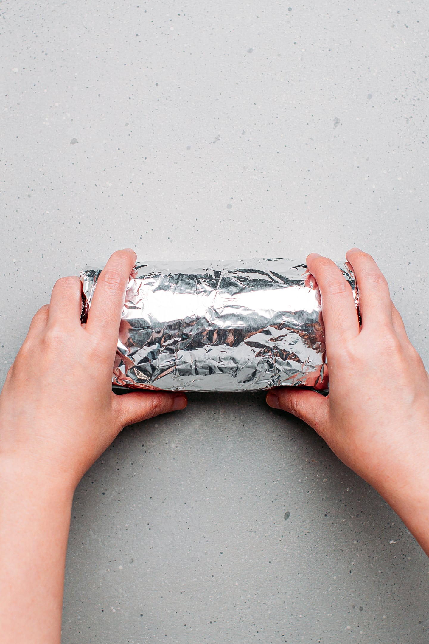 Rolling vegan bologna in aluminum foil.