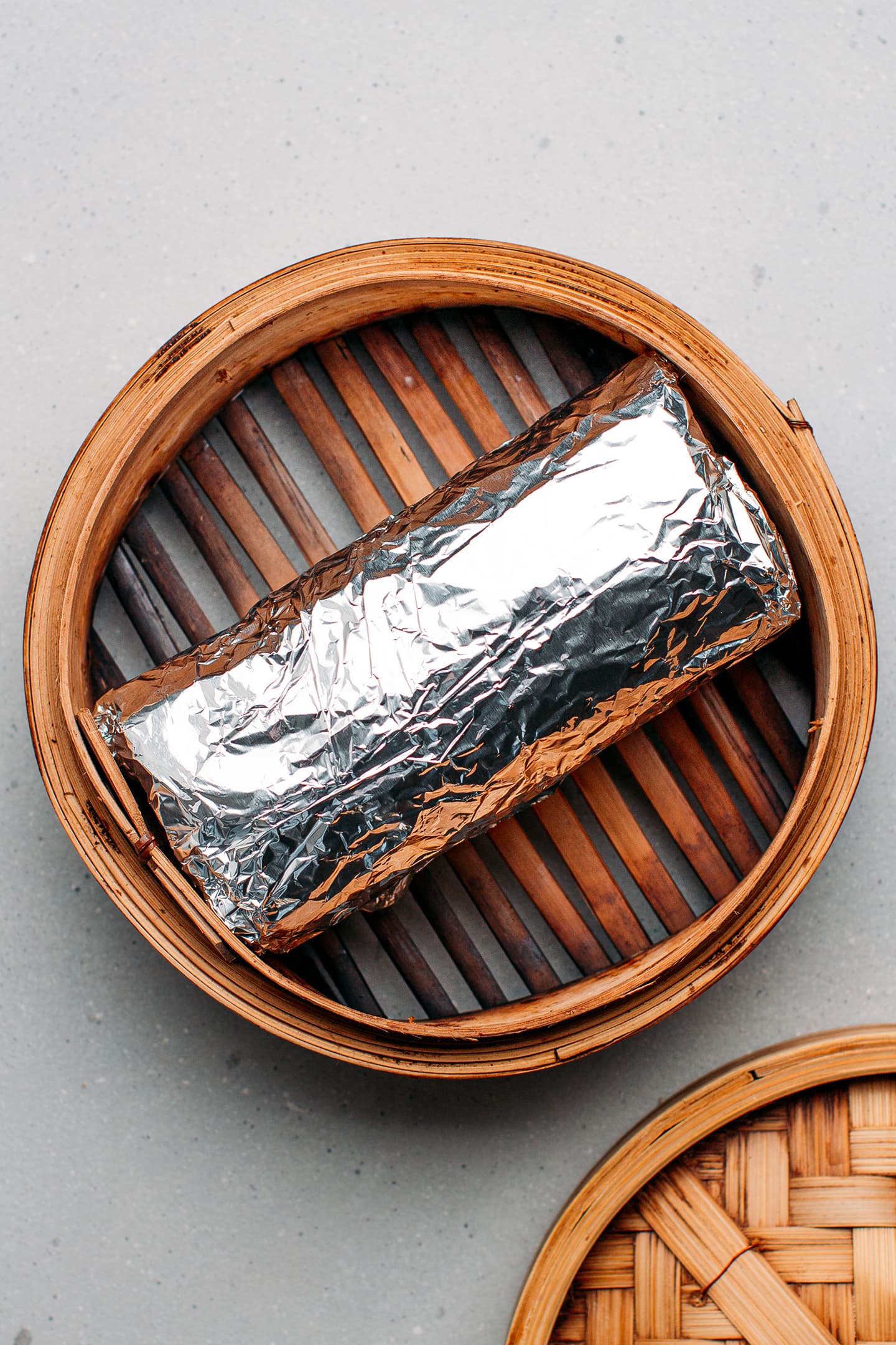 Vegan baloney wrapped in aluminum foil and placed in a steamer.