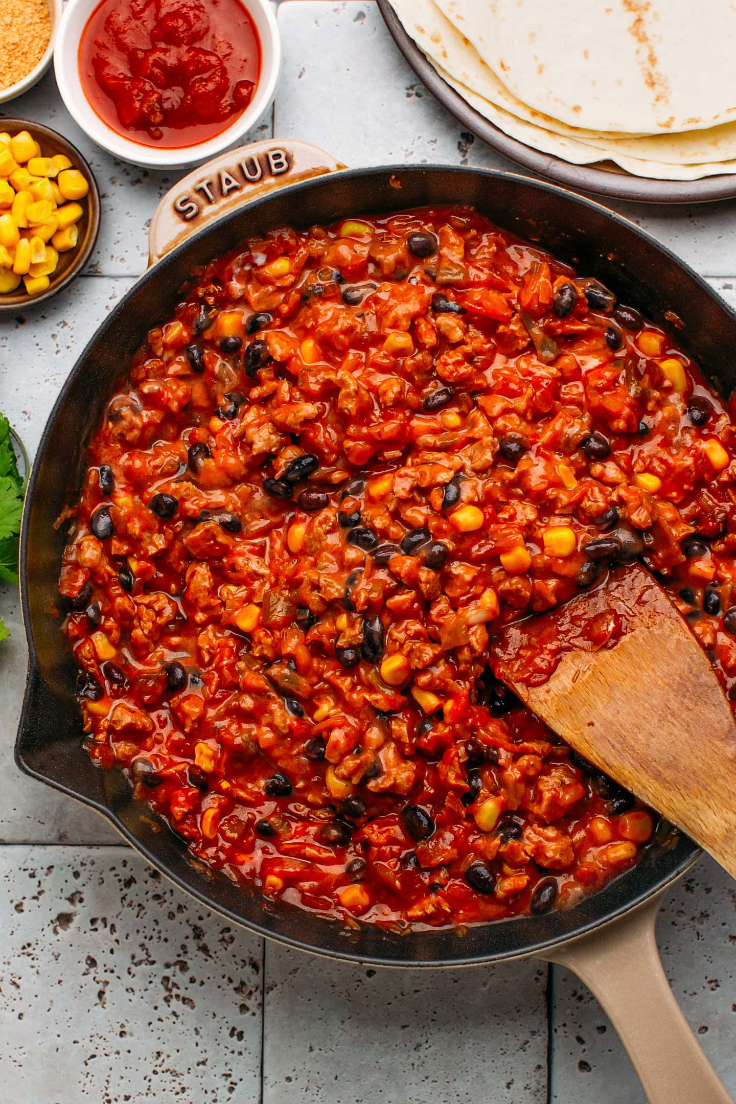 Beans, corn, and enchilada sauce in a skillet.