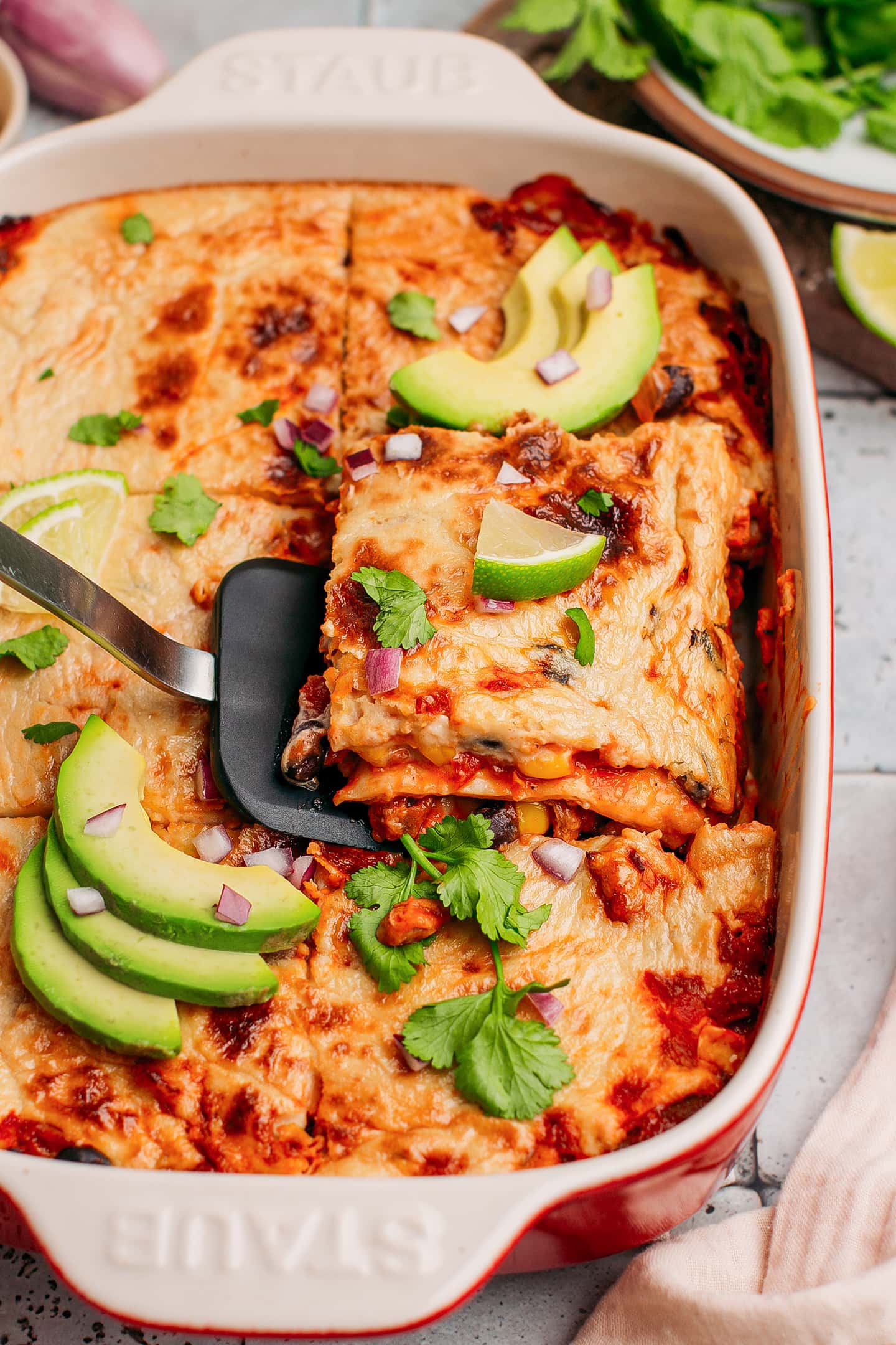 Serving of enchilada casserole in a baking dish.