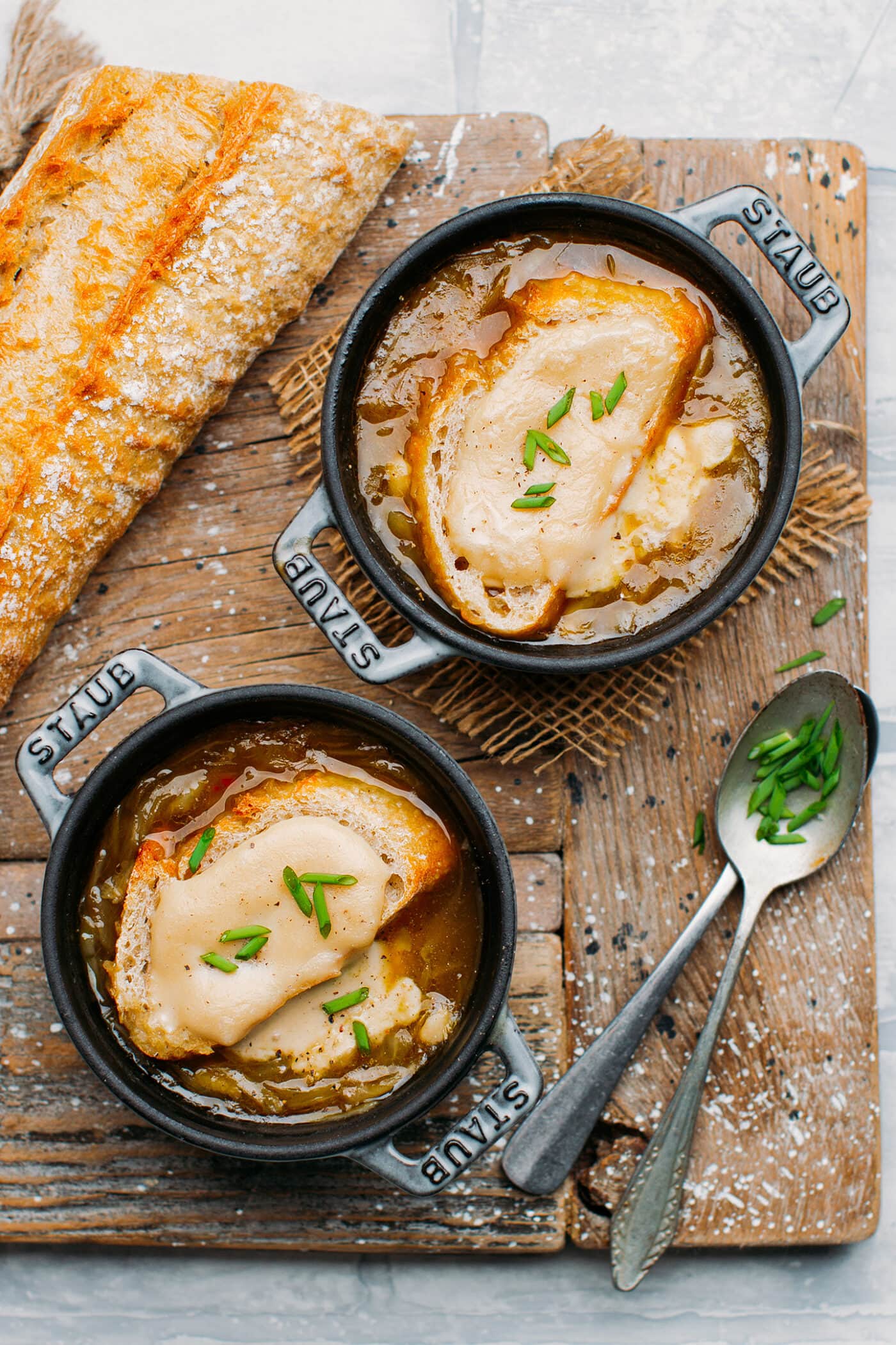 Vegan onion soup in mini cocottes with bread and cheeese.