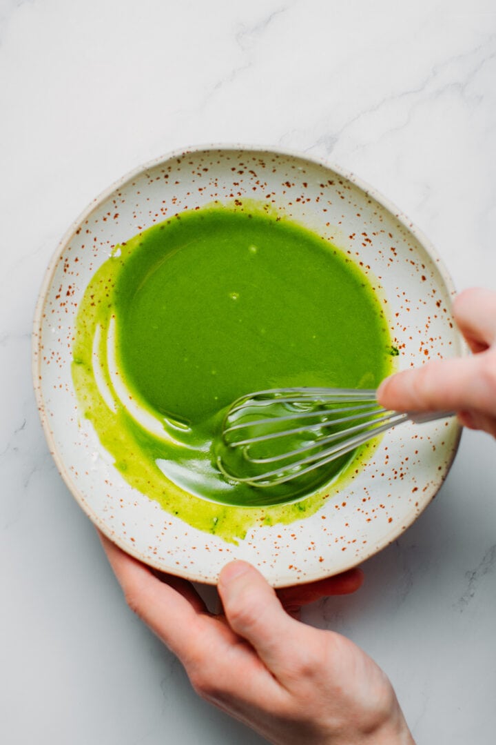 Whisking cacao butter, powdered sugar, and matcha.