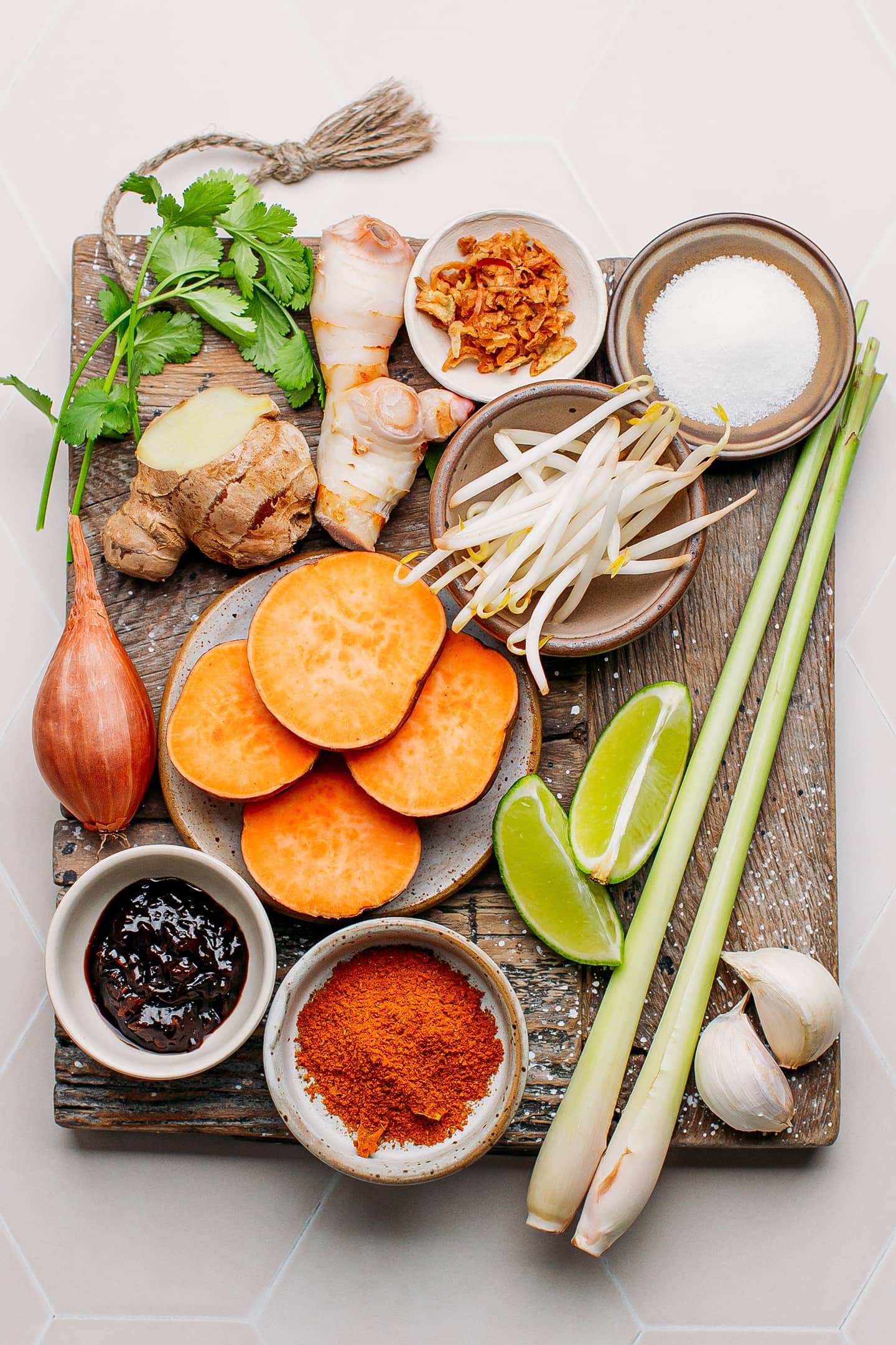 Ingredients like sweet potatoes, shallots, garlic, galangal, and lemongrass.