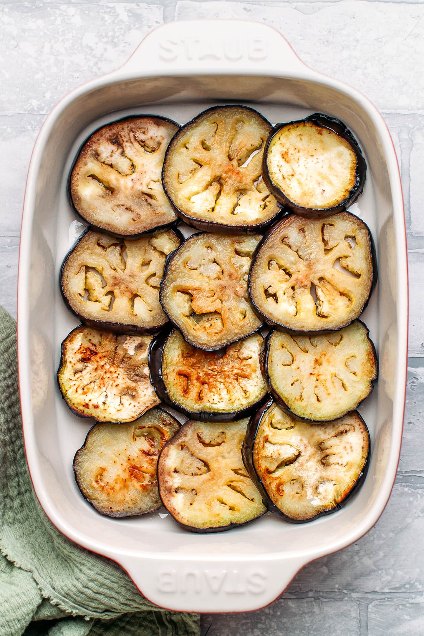 Sautéed eggplant slices in a baking dish.