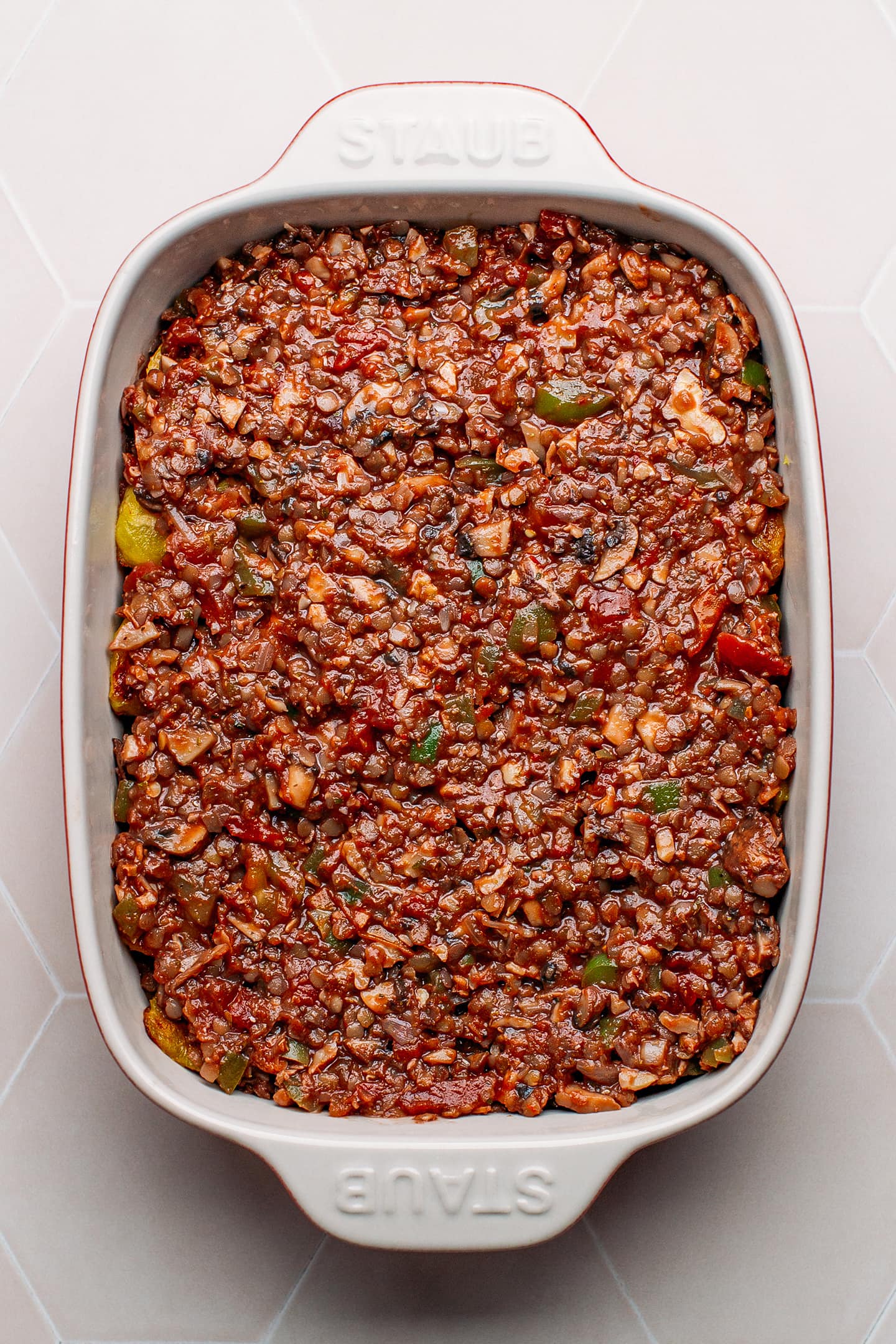 Plantains topped with vegan bolognese in a baking dish.