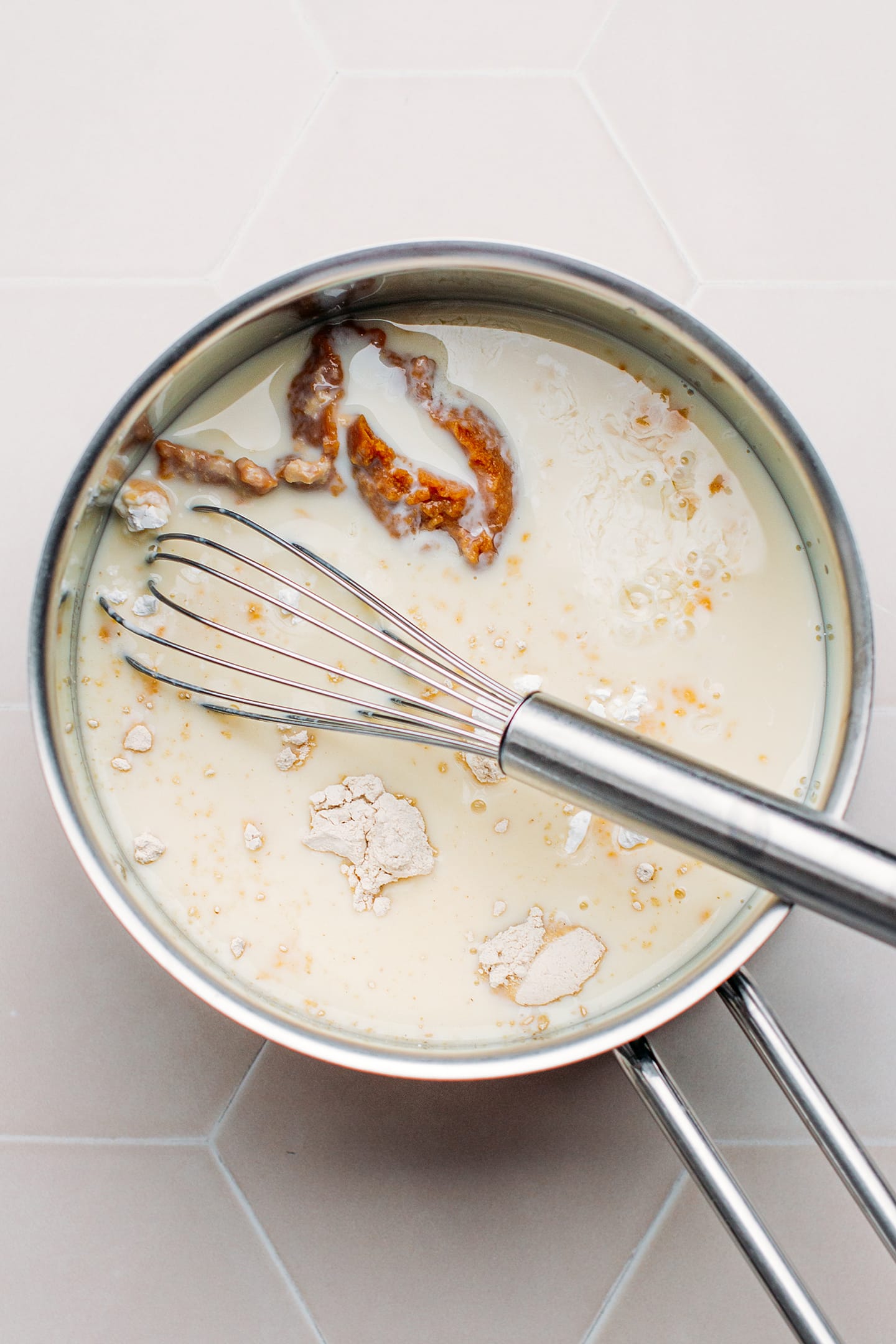 Whisking almond milk, miso, and cornstarch in a saucepan.