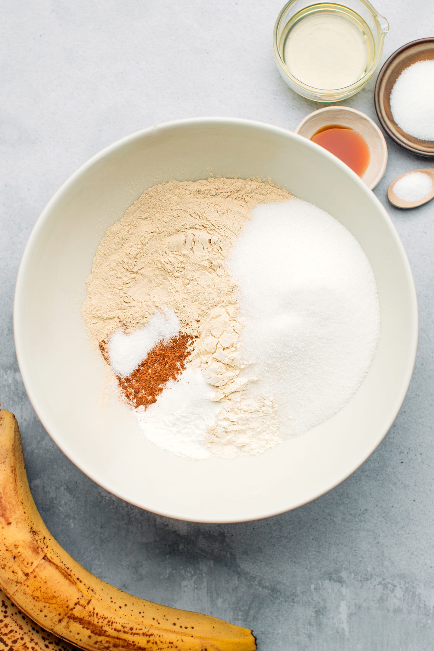 Flour, protein powder, sugar, and cinnamon in a bowl.