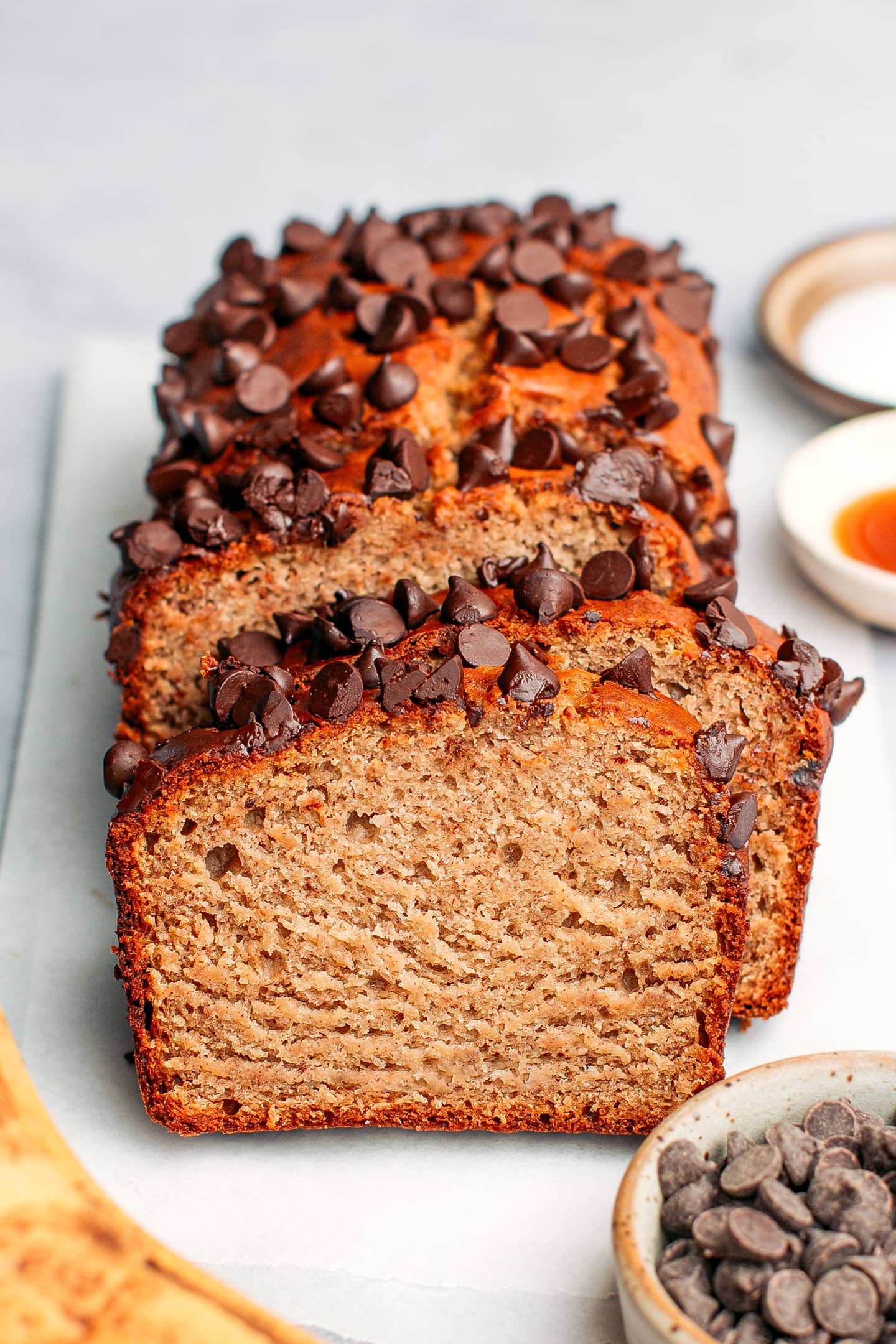 Sliced protein banana bread topped with chocolate chips.