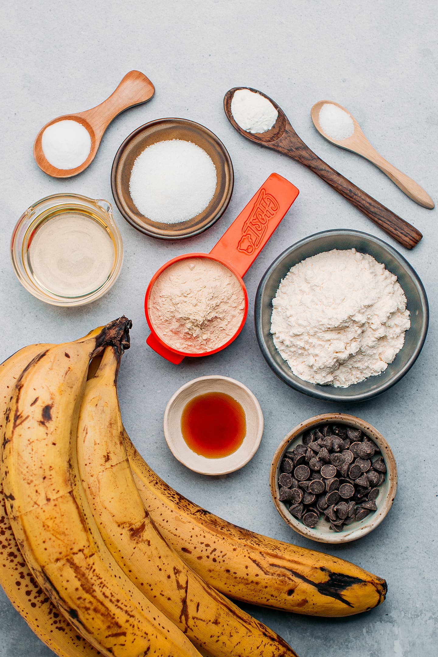 Ingredients like bananas, flour, protein powder, chocolate chips, and vanilla extract.