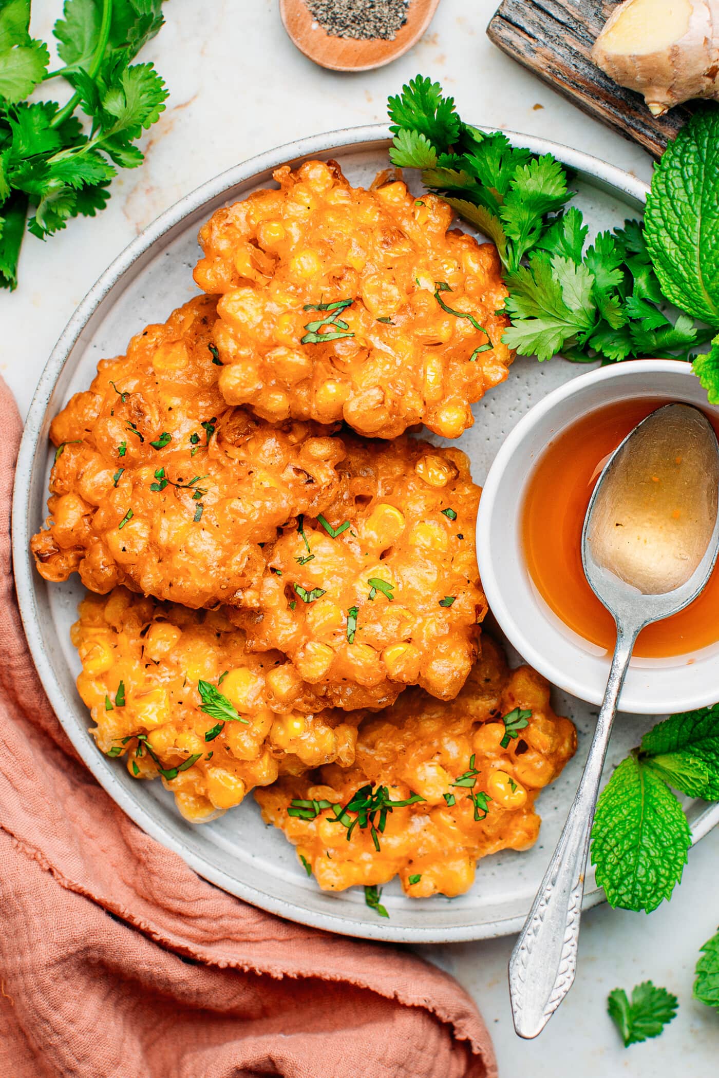 Corn fritters topped with cilantro on a plate.