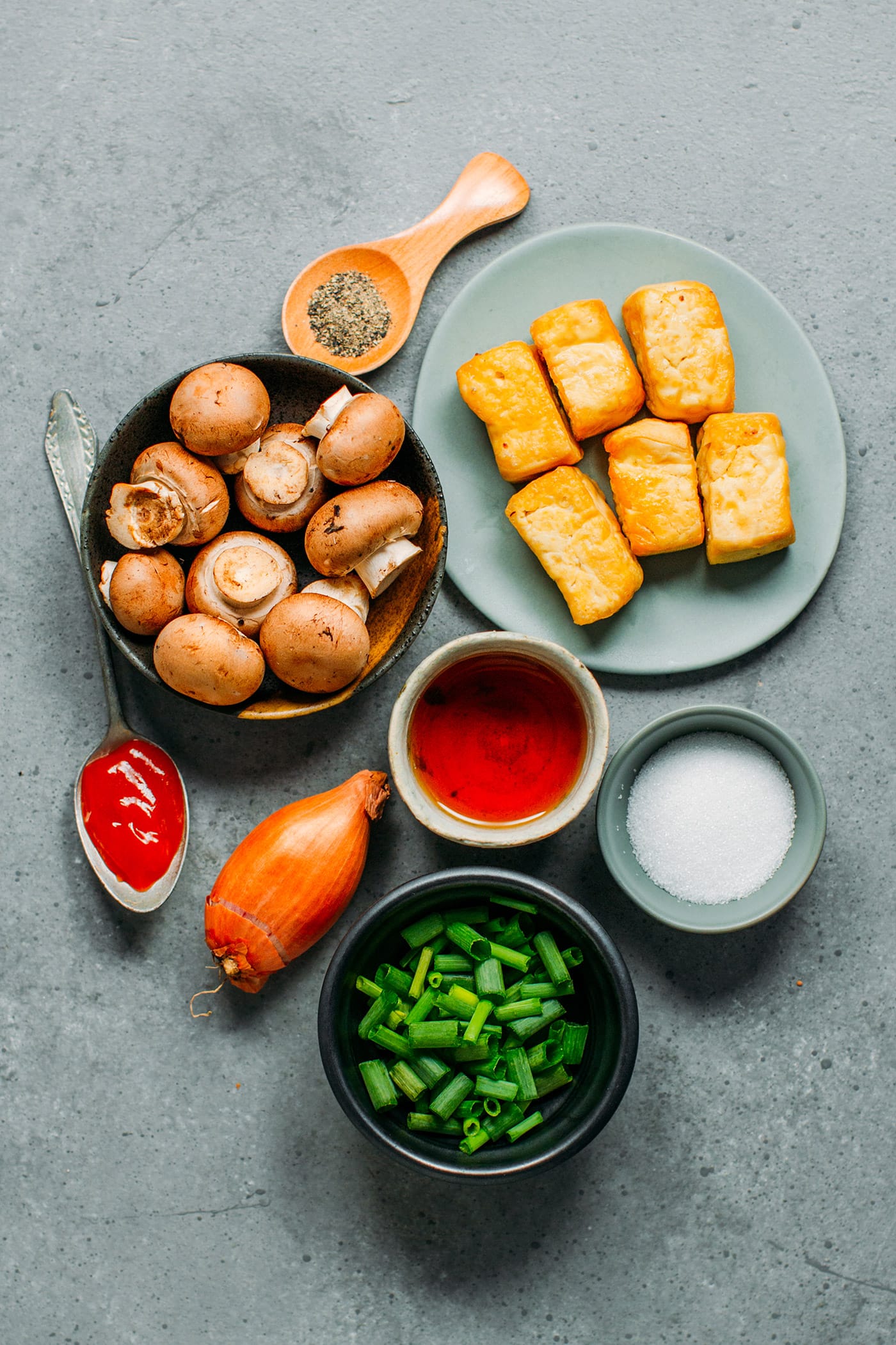 Ingredients like fried tofu, mushrooms, fish sauce, sugar, green onions