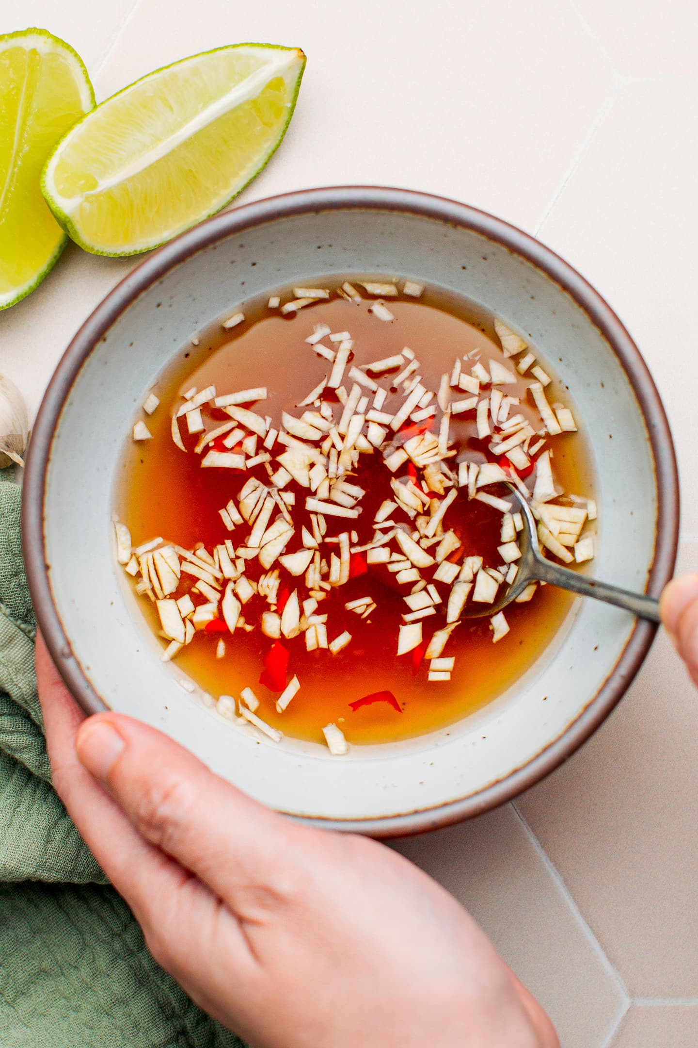 Stirring Vietnamese dipping sauce in a bowl.