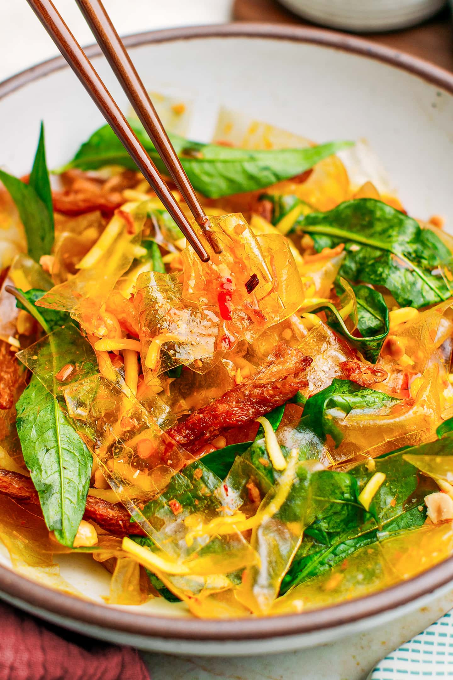 Close-up of banh trang tron with green mango and Vietnamese coriander.